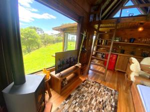 邦雷蒂鲁Chalé Eco das Aves próximo a vinícola Thera的一间客厅,内设大窗户