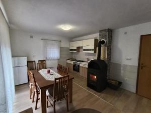 a kitchen and dining room with a table and a stove at Divan Vlašić in Šišava