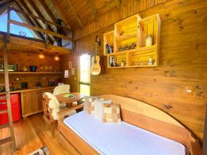 邦雷蒂鲁Chalé Eco das Aves próximo a vinícola Thera的带床和木墙的卧室