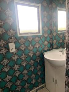 une salle de bain avec un lavabo et des toilettes et une fenêtre dans l'établissement Mobil Home Vintage à la Ferme des buttons, à Rosnay