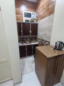 eine kleine Küche mit Spüle und Mikrowelle in der Unterkunft روعة أجا للشقق المخدومة in Ha'il