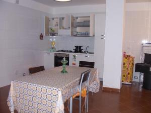 eine Küche mit einem Tisch mit einer Tischdecke in der Unterkunft Casa Fortuna in Il Monte