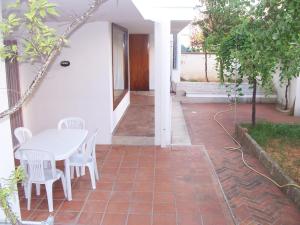 eine Terrasse mit einem weißen Tisch und weißen Stühlen in der Unterkunft Casa Fortuna in Il Monte + 2 Fotos