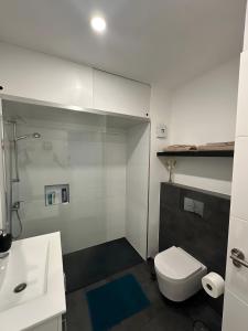 Un baño blanco con inodoro y lavabo. en La Casita De Santiago, en Playa de Santiago