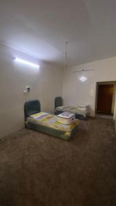 una habitación vacía con dos camas y una puerta en نُزل الهدا, en Taif