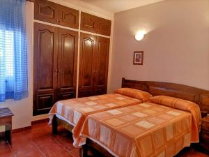 een slaapkamer met een bed en houten kasten bij Casa La Canela in Playa de Santiago