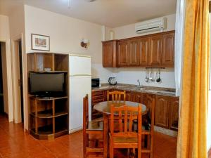 een keuken met een tafel en een witte koelkast bij Casa La Canela in Playa de Santiago