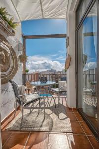 Un patio con una mesa y sillas en un balcón. en Casa Amaoré, en Playa de Santiago