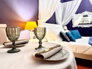a room with a table with two glasses and a bed at Villa Meraville in Bologna