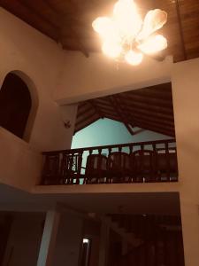 Cette chambre dispose d'un balcon avec des chaises et un lustre. dans l'établissement Bentota Lotus Resort and Villa Bentota, à Hettiwatta