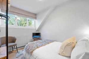ein Schlafzimmer mit einem Bett und einem Stuhl und Fenstern in der Unterkunft Cosy 3 Bed with Parking in Bilton + 27 Fotos
