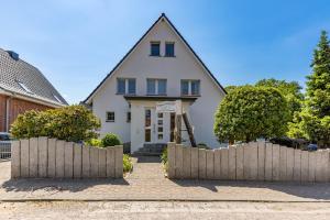 a house with a fence in front of it at Strand Quartier in Timmendorfer Strand