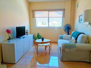 ein Wohnzimmer mit Fernseher, Couch und Tisch in der Unterkunft Miramar 2 in San Sebastián de la Gomera