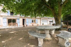 a stone table and benches under a tree at En savanac in Albiac