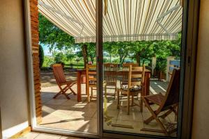 a glass door of a patio with a table and chairs at En savanac in Albiac