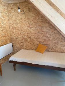 un lit dans une chambre avec un mur en bois dans l'établissement Le Nid, à Abbaretz 11 autres photos