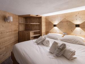 Un dormitorio con una gran cama blanca con paredes de madera. en Duplex rénové proche pistes, 6 pers, animaux bienvenus, Wi-Fi - FR-1-640-41, en Val Thorens 7 fotos más