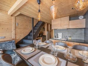 Un comedor con mesa y sillas y una escalera. en Duplex rénové proche pistes, 6 pers, animaux bienvenus, Wi-Fi - FR-1-640-41, en Val Thorens