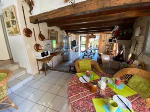 a living room with a table and chairs and a kitchen at Hôtel restaurant de la fontaine in Villiers-sur-Suize
