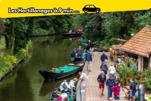 a group of people standing on a dock with boats at LE 219 - Maison tout confort à Amiens Wi-Fi rapide, Netflix, calme & proche centre in Amiens