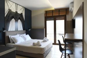 a bedroom with a bed with a desk and a table at 4 Seasons Luxury Apartments in Alexandroupoli