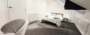 une chambre blanche avec un lit et une chaise dans l'établissement The Spacious Urban Retreat, à Douglas
