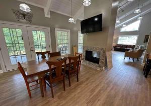 une salle à manger et un salon avec une table et une cheminée dans l'établissement Brushy Creek Lodge - Riverfront, Hot Tub, Fire Pit, à Mentone