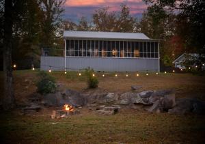 un bâtiment avec un feu devant lui la nuit dans l'établissement Brushy Creek Lodge - Riverfront, Hot Tub, Fire Pit, à Mentone