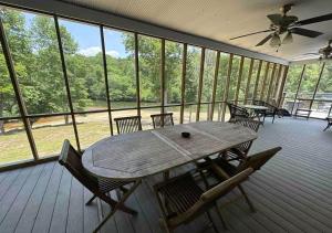 - une table et des chaises en bois sur une terrasse couverte dans l'établissement Brushy Creek Lodge - Riverfront, Hot Tub, Fire Pit, à Mentone