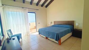 a bedroom with a blue bed and a large window at Casa Micaela - Exclusive in Playa de Santiago