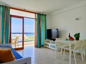 a living room with a television and a table with chairs at Casa Marazul in Costa de Adeje