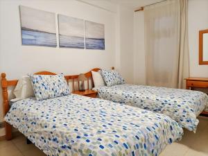 a bedroom with two beds with blue and white sheets at Casa Marazul in Costa de Adeje +6 photos