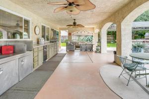 a large kitchen with a ceiling fan and a table at Outdoor Kitchen & Patio! Central Valley Hacienda in Atwater