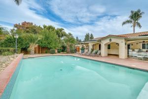 a swimming pool in front of a house at Outdoor Kitchen & Patio! Central Valley Hacienda in Atwater