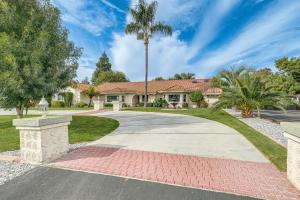 a house with a palm tree and a driveway at Outdoor Kitchen & Patio! Central Valley Hacienda in Atwater