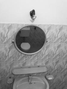 une salle de bain avec un miroir au-dessus des toilettes dans l'établissement Bentota Lotus Resort and Villa Bentota, à Hettiwatta