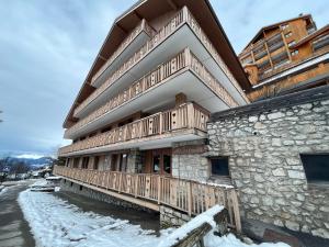 a building with wooden balconies on the side of it at Appartement rénové 3* au centre de Méribel avec balcon et WiFi - FR-1-688-23 in Méribel