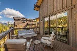 a deck with chairs and tables on a balcony at Spanish Peaks - Highlands Cabin 59 in Big Sky