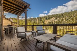 a deck with chairs and tables and a view of the mountains at Spanish Peaks - Highlands Cabin 59 in Big Sky