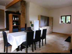 comedor con mesa blanca y sillas negras en Chez Rambaud, en Chadaleix