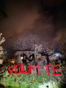 维尔蒂尼克Brvnare - Ranč Platan的夜晚，房子前立着一块写着“vulinne”的牌子。