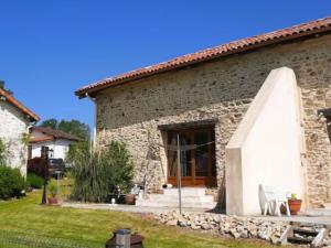 una casa de piedra con una puerta de madera y un patio en Chez Rambaud, en Chadaleix