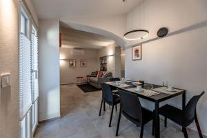 ein Esszimmer mit Tisch und Stühlen und ein Wohnzimmer in der Unterkunft Alta Via 2 - Free Parking - Sea 20 min - A-C in Altare