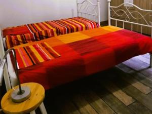 Una cama con una manta roja y amarilla y una mesa. en Chez Rambaud, en Chadaleix 16 fotos más