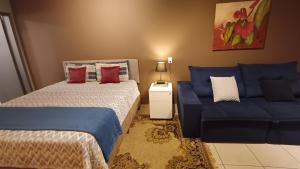 a bedroom with two beds and a blue couch at Studio Barreto Leme Ap72 in Campinas