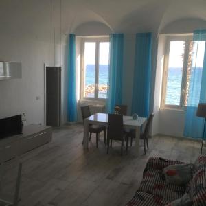 a living room with a table and chairs and the ocean at Casa al Prino in Imperia