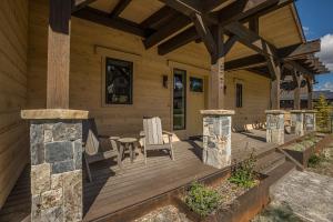 a wooden porch with a table and chairs on it at Spanish Peaks - Highlands Cabin 59 in Big Sky +7 photos