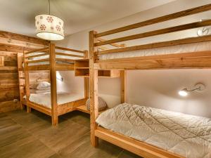 a bedroom with two bunk beds and a lamp at Chalet 3 chambres - Sauna et salle de sport - 8 pers - FR-1-685-91 in Les Gets