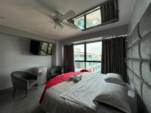 a bedroom with a bed and a large window at Hotel Hyds in Lima