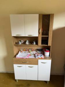 einen weißen Schrank mit einem Tisch in einem Zimmer in der Unterkunft Recanto Zechini in Vargem Alta + 11 Fotos